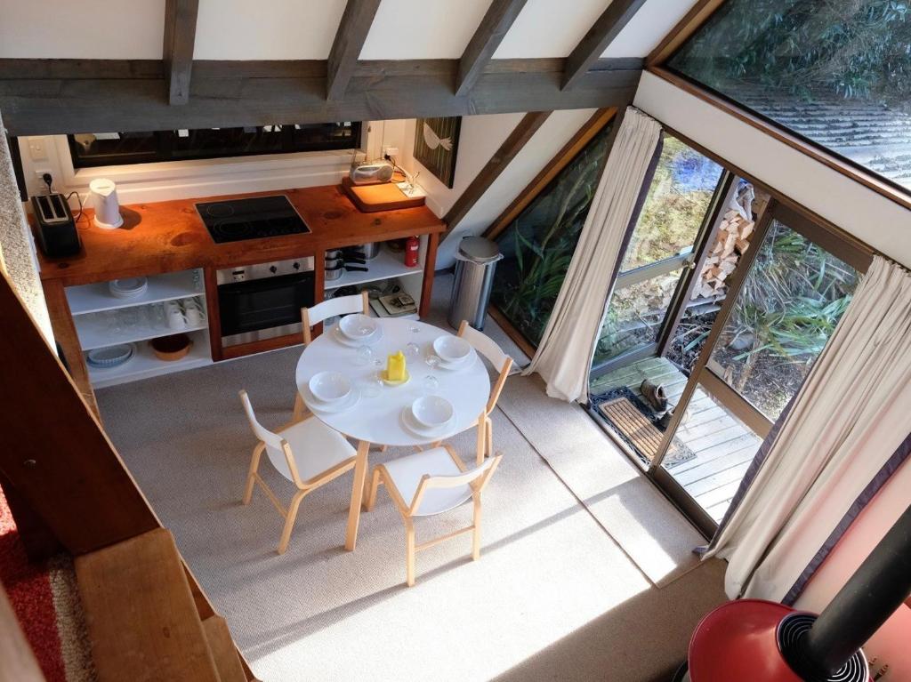 an overhead view of a table and chairs in a tiny house at Adventure A-Frame - Ohakune Holiday Home in Ohakune