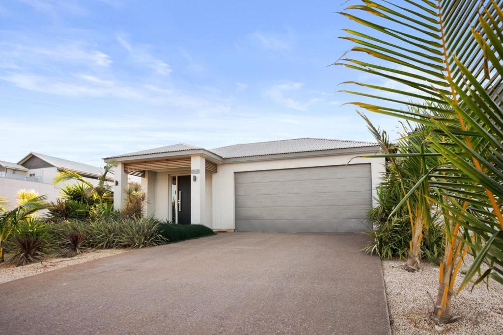 una casa blanca con garaje en 108 Madaffari Drive, en Exmouth