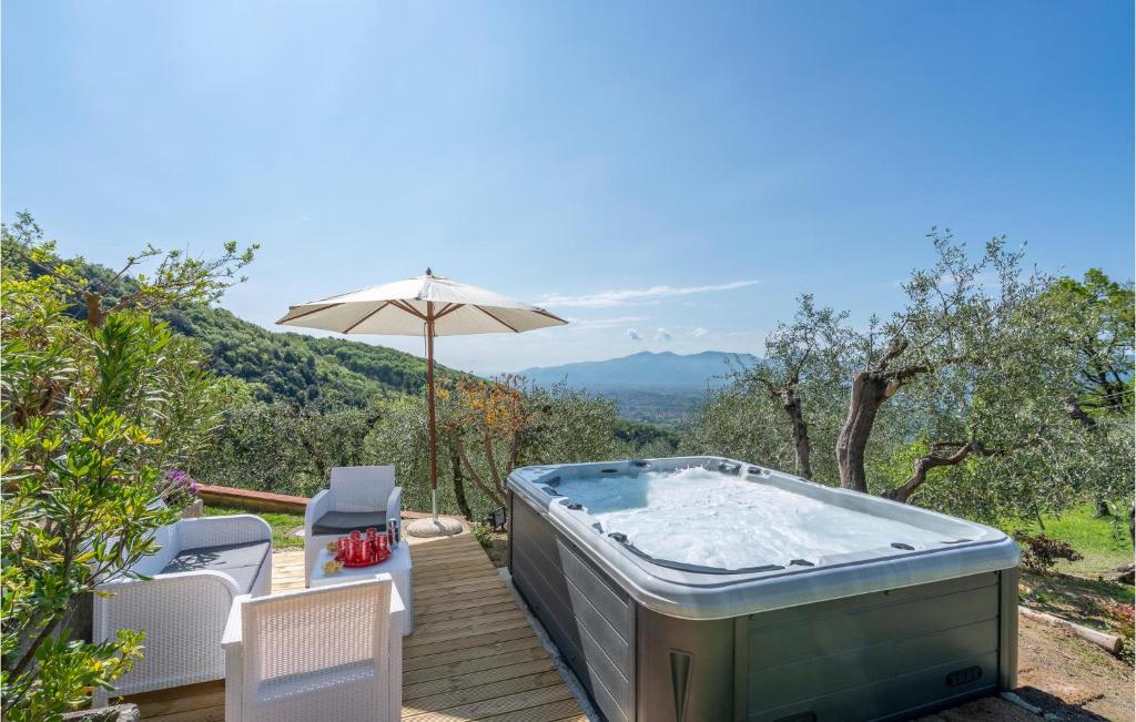 a hot tub on a wooden deck with an umbrella at Montecatino in Mastiano