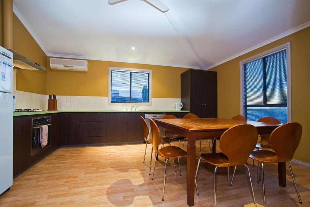 a kitchen with a wooden table and chairs at 9 Skipjack Circle in Exmouth