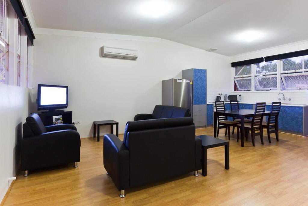 a living room with chairs and a table and a television at Exmouth Villas Unit 33 in Exmouth