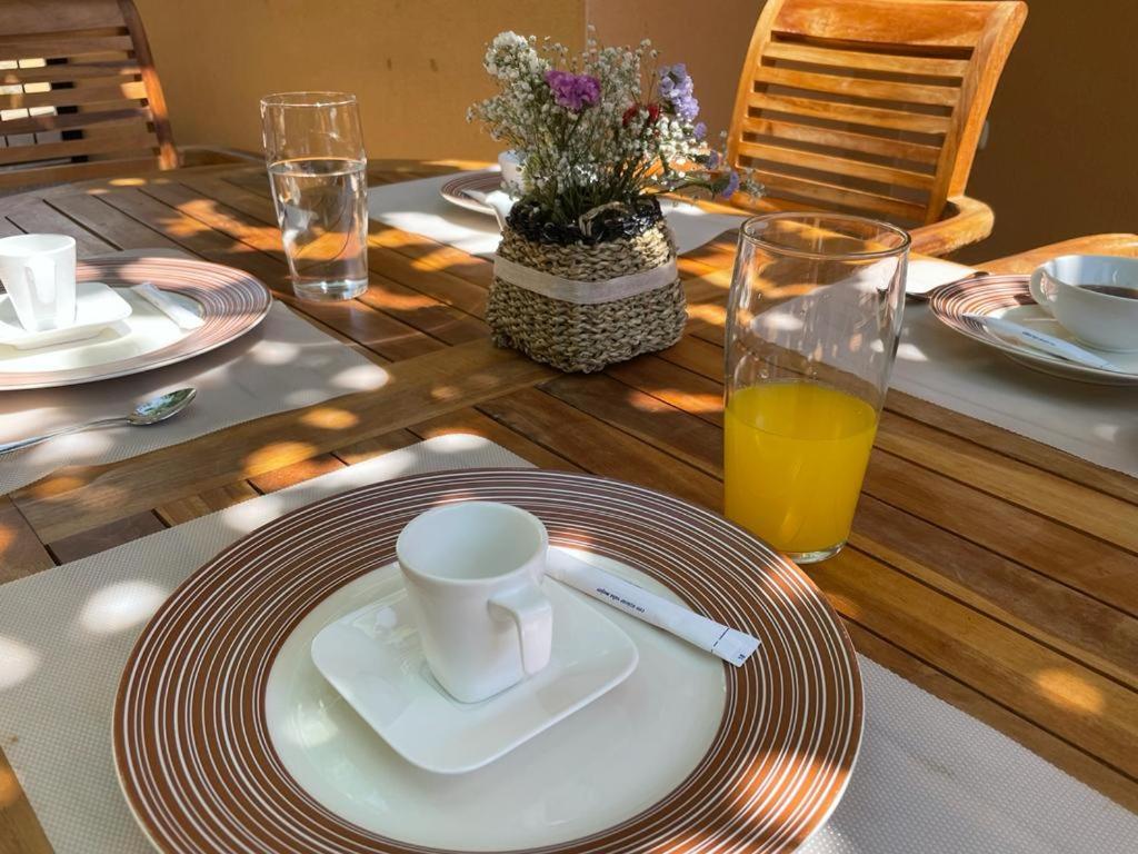 a table with a plate with a coffee cup and a glass of orange juice at Casa con Encanto,disfruta de su paz y tranquilidad in Adzaneta