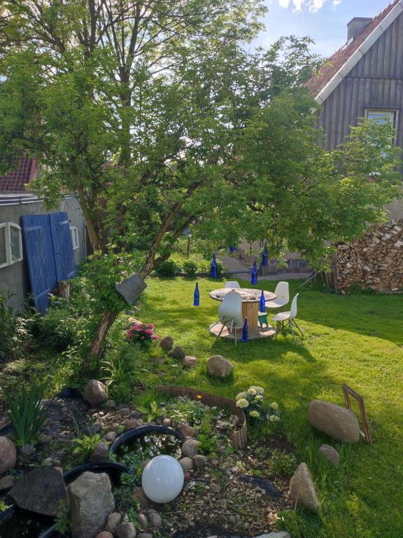 ogród ze stawem, stołem i krzesłami w obiekcie Twórcze Poddasze Elgnowo w mieście Dąbrówno