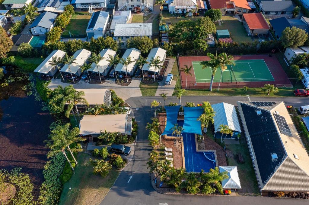 an overhead view of a row of houses with a tennis court at Discovery Parks - Fraser Street, Hervey Bay in Hervey Bay