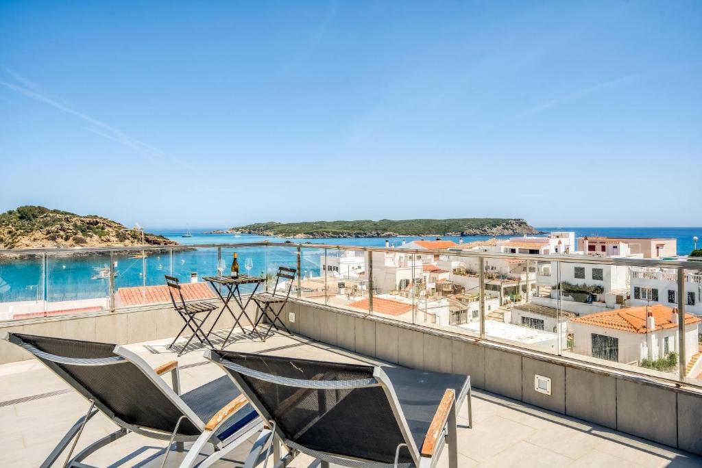 a balcony with two chairs and a view of the ocean at Apartamento en Es Grau con vistas in Mahón