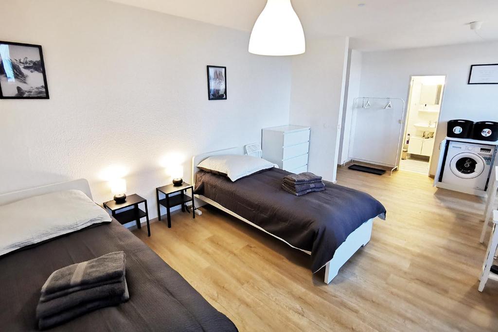 ダルムシュタットにある1 room flat in Darmstadtのベッド2台、キッチンが備わる広い客室です。