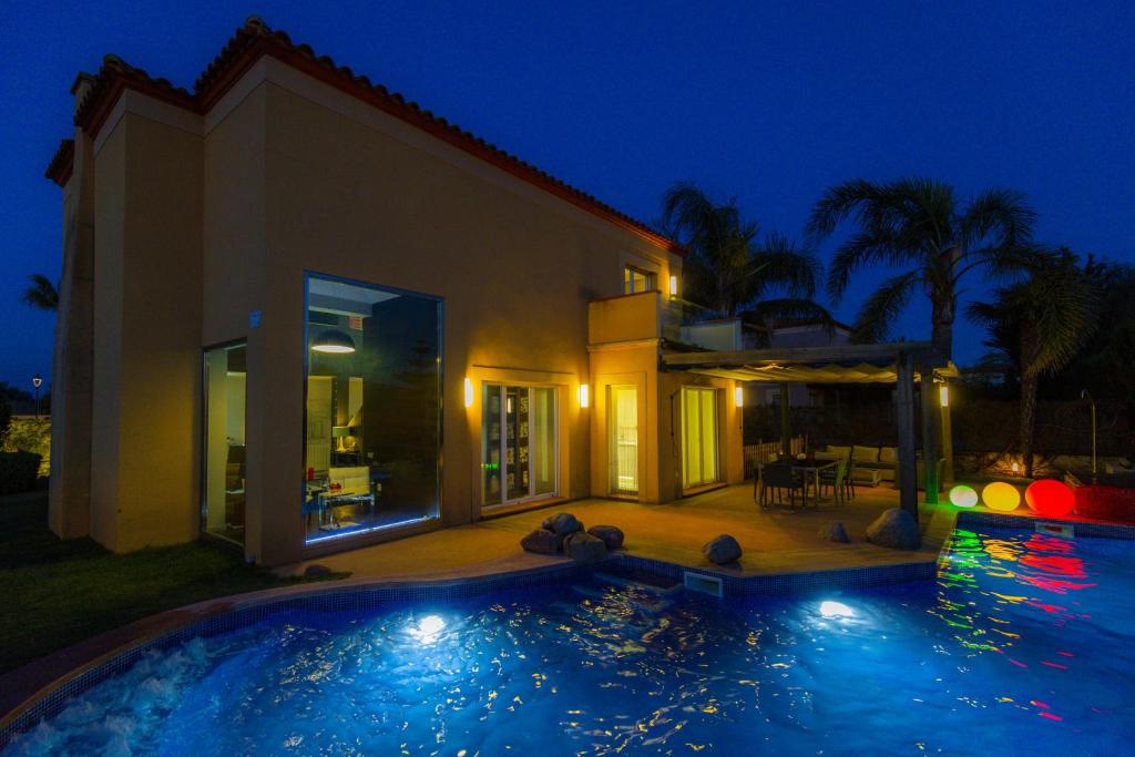 a house with a swimming pool at night at ZENLUXE Villa Planet Costa Dorada in Reus