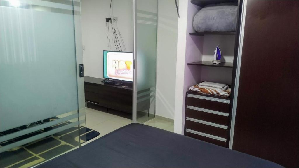 um quarto com uma televisão e um armário de vidro em EQUIPETROL Apartamento Entero BARUC DOS # 27 em Santa Cruz de la Sierra