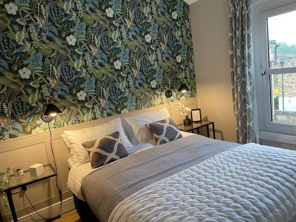 een slaapkamer met een groot bed met bloemenbehang bij No 73 Aparthotel by condokeeper in Cambridge