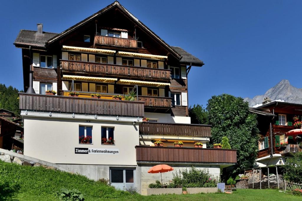 een groot gebouw met balkons en een oranje paraplu bij Studio Eigerblick in Grindelwald