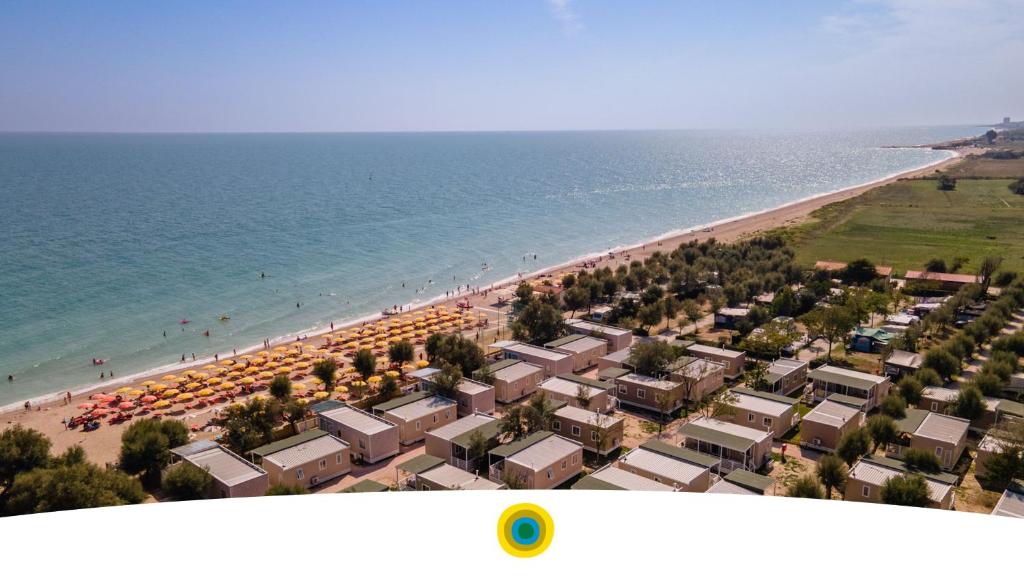 an aerial view of a beach with umbrellas at La Risacca Family Camping Village in Porto SantʼElpidio