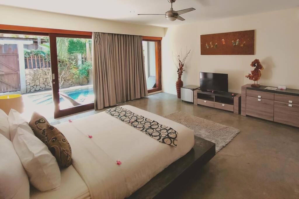 1 dormitorio grande con 1 cama grande y TV en VIILA JAHE, en Kuta Lombok