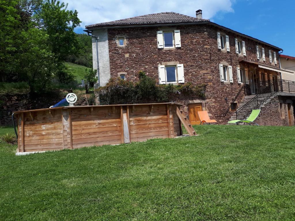 een huis met een houten hek in de tuin bij Gîte Les Paredous in Broquiès