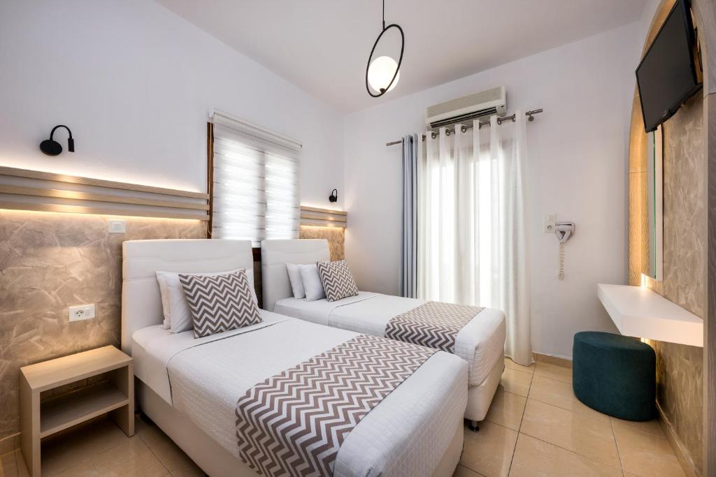 a hotel room with two beds and a tv at Petros Villa in Fira