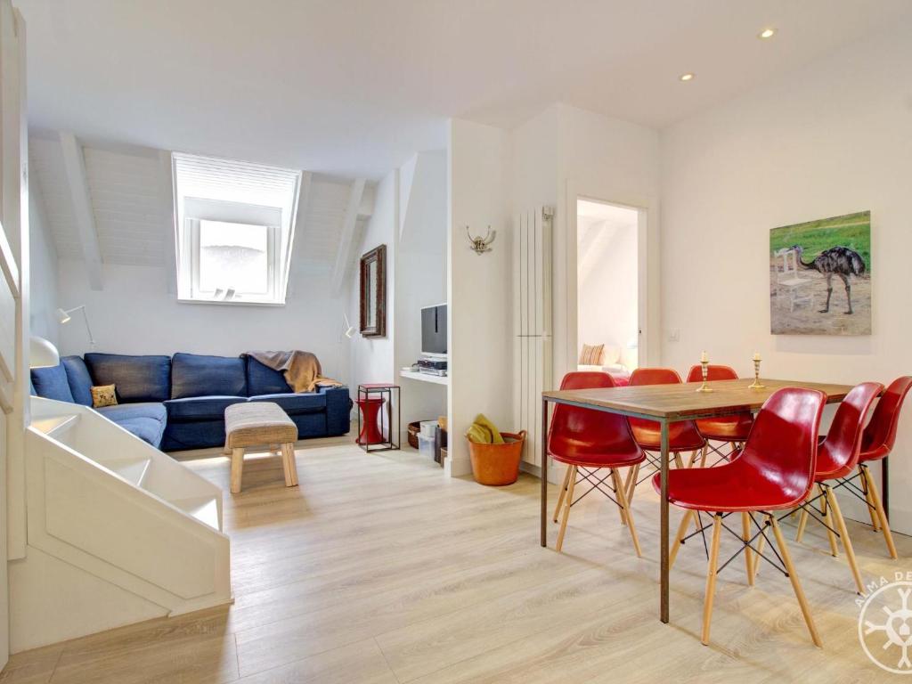 a living room with a table and red chairs at BLANHIBLAR de Alma de Nieve in Baqueira-Beret