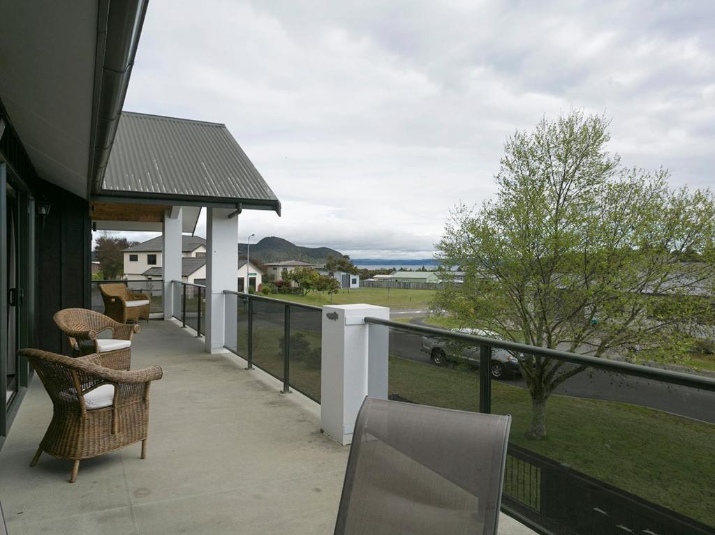 einen Balkon mit Stühlen und Meerblick in der Unterkunft Lake Magic - Motuoapa Holiday Home in Turangi