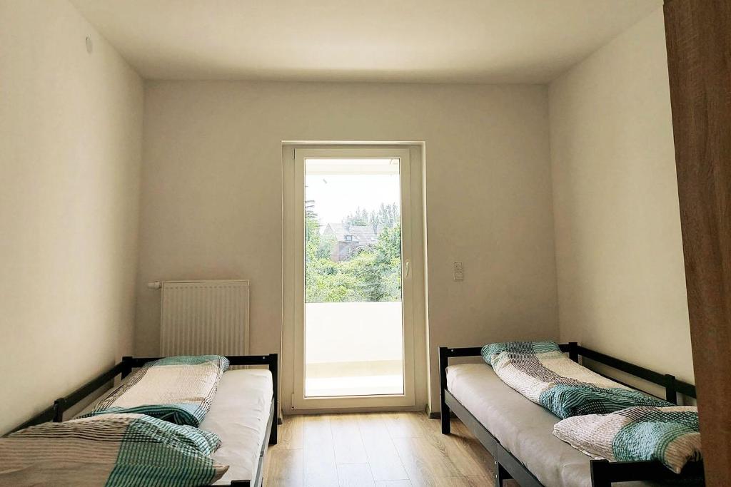 two beds in a room with a window at 4 room apartment in Düren in Düren - Eifel