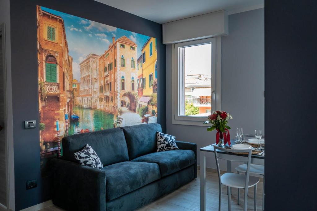 a living room with a blue couch next to a window at Little Venice in Sottomarina
