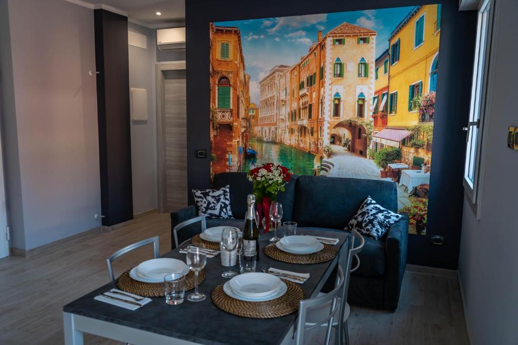 a dining room with a table and a painting on the wall at Little Venice in Sottomarina