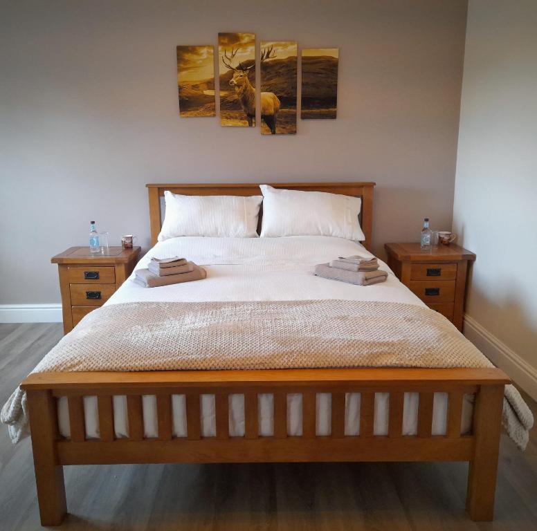 a bedroom with a bed with two paintings on the wall at The Cottage Inn in Llandeilo