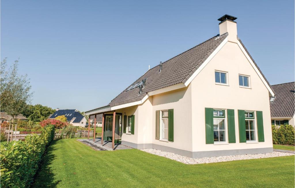 una casa bianca con finestre verdi e un cortile di Nice Home In Vlagtwedde With Wifi a Vlagtwedde