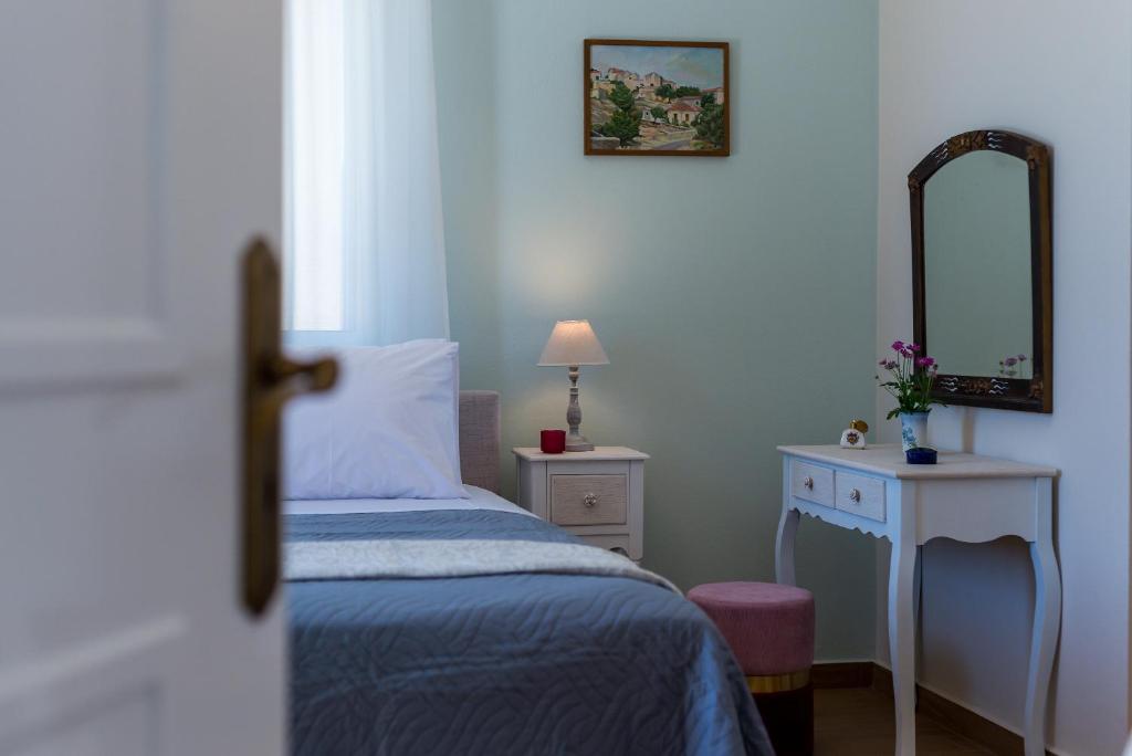 sypialnia z łóżkiem, lustrem i stołem w obiekcie Villa Remedio w mieście Néon Khoríon