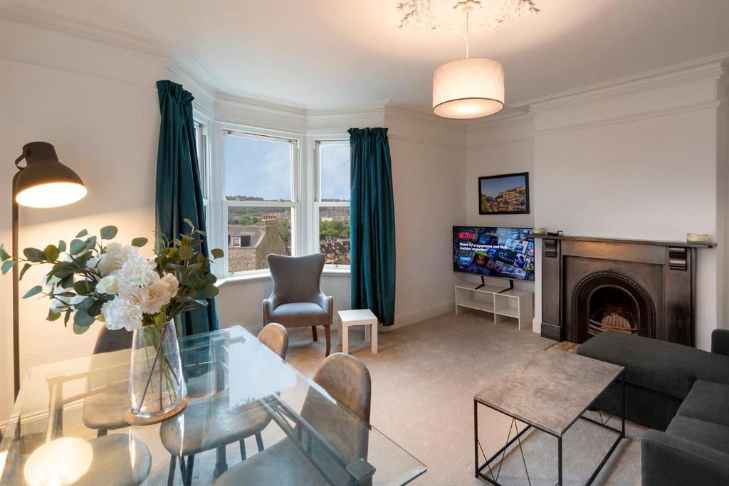 ein Wohnzimmer mit einem Tisch und einem Kamin in der Unterkunft Beautiful views! 3 great doubles! in Bath