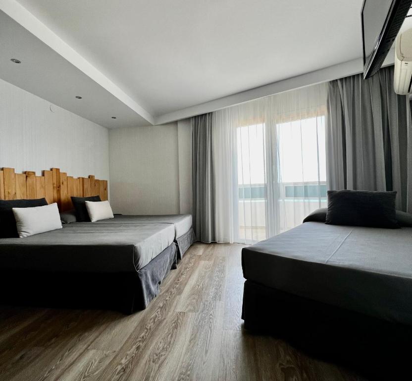 Postel nebo postele na pokoji v ubytování Hotel Hey Peñíscola