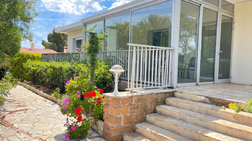 uma casa com portas de vidro e flores no quintal em Villa conviviale et familiale proche du Port Santa em Saint-Raphaël