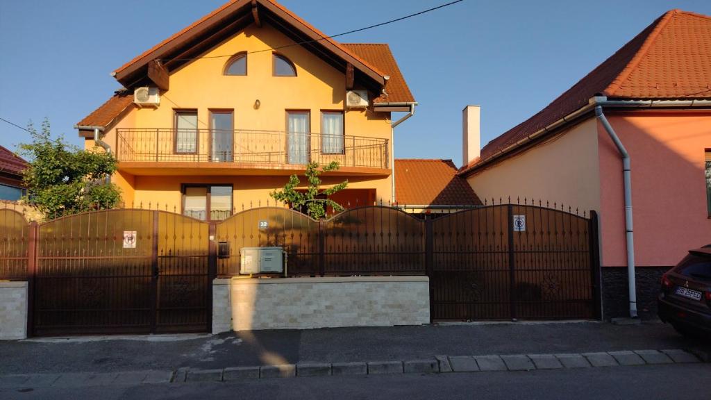 a yellow house with a fence in front of it at Casa Ienciu in Sibiu
