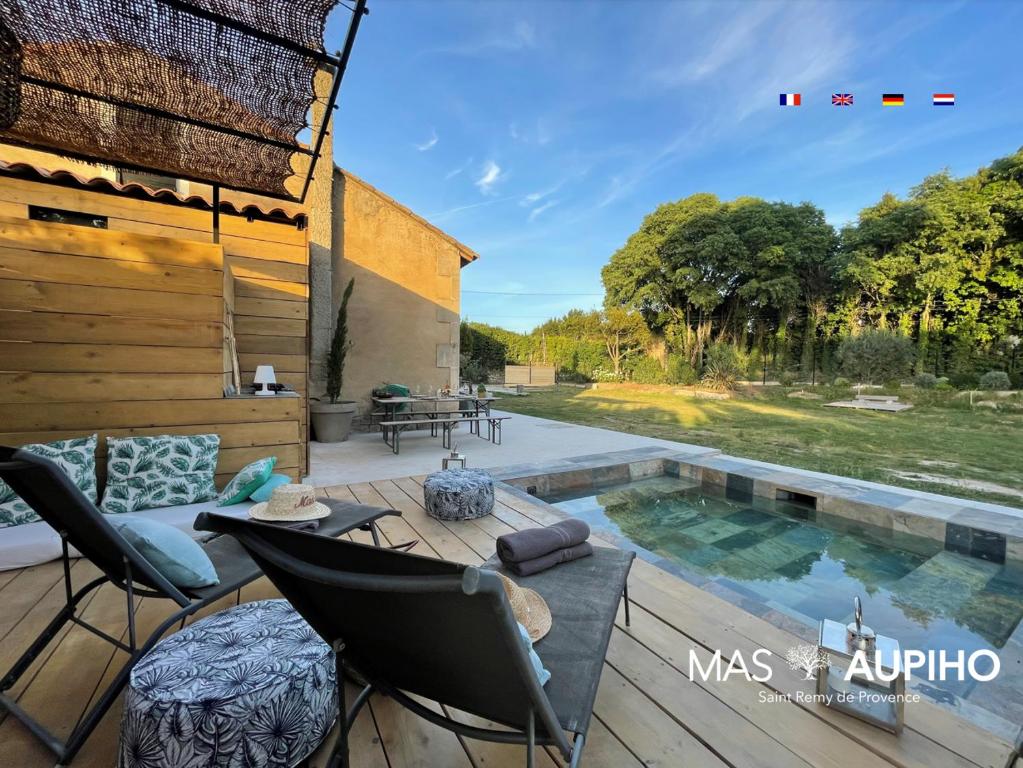 een patio met stoelen en een zwembad bij Mas Aupiho in Saint-Rémy-de-Provence