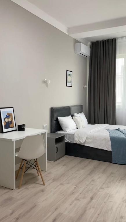 a bedroom with a bed and a desk and a computer at Жилой Комплекс Акжайык in Astana