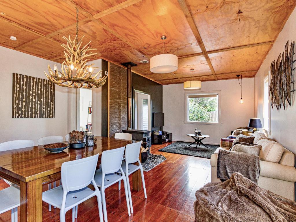 a dining room and living room with a table and chairs at Stag & 3 Pigs - Ohakune Holiday Home in Ohakune