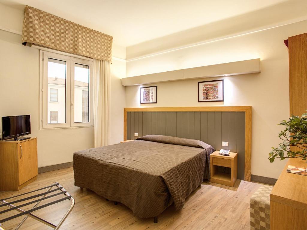 a bedroom with a large bed and a large window at Hotel Delle Nazioni in Florence