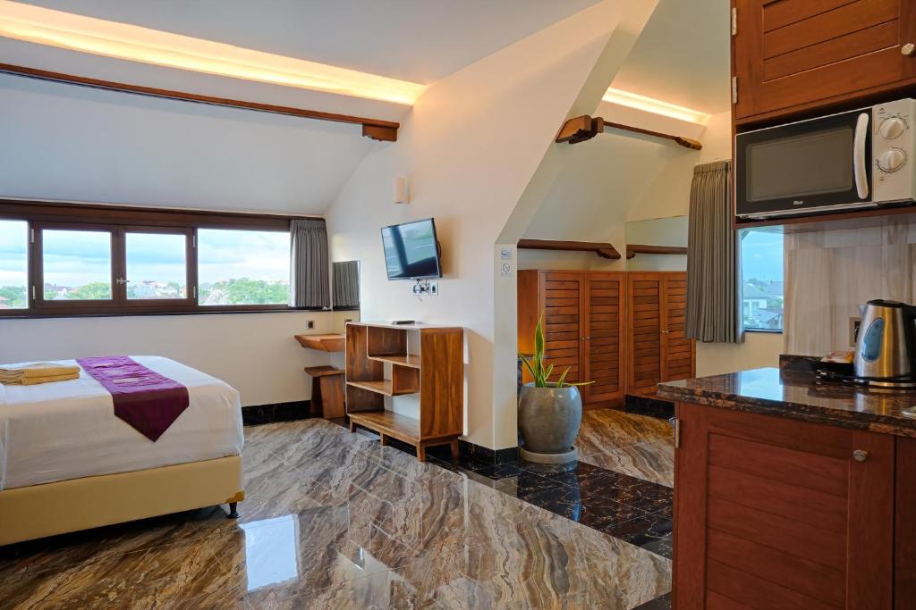 a hotel room with a bed and a kitchen at Kyara Villa Apartments in Canggu