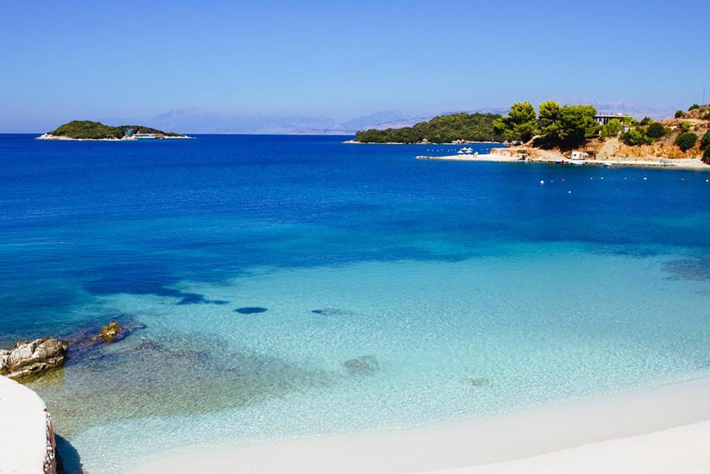 una playa con un gran cuerpo de agua azul en Apartments Neri, en Ksamil