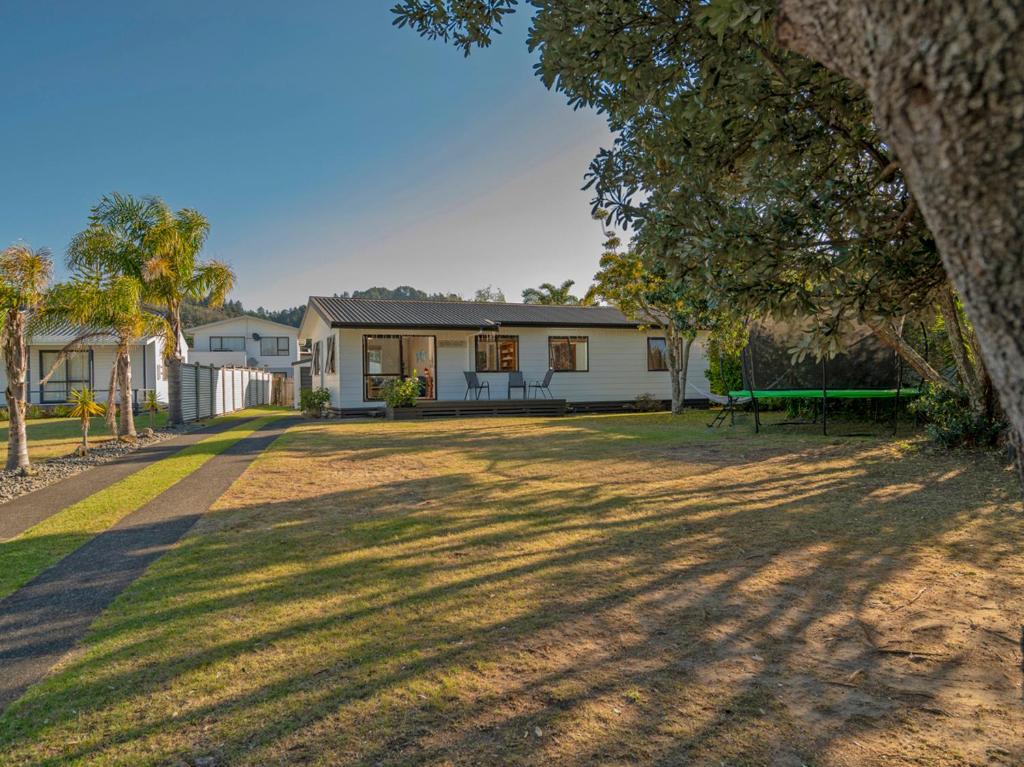 a house with a picnic table in the yard at Wonderful Whangamata - Whangamata Holiday Home in Whangamata