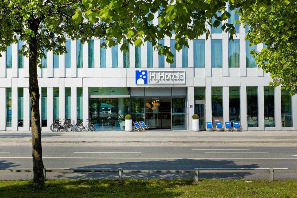 a building with blue chairs in front of a street at H2 Hotel München Messe in Munich