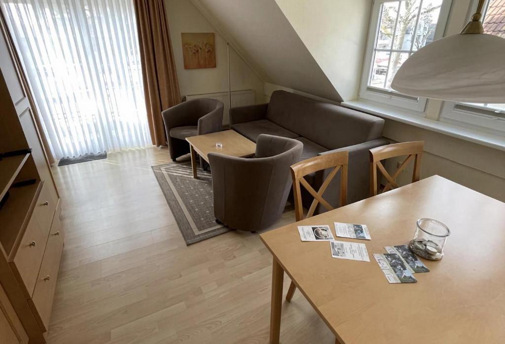 a living room with a couch and a table and chairs at Haus Kiek Ut Apartment 26 in Timmendorfer Strand