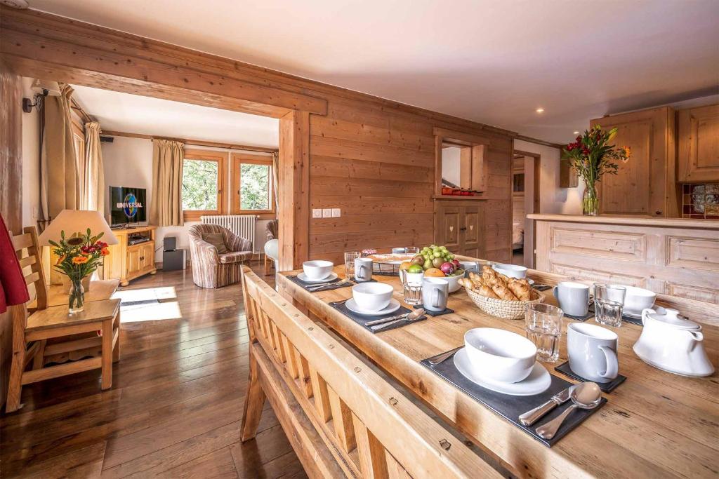 una cocina con una gran mesa de madera con comida. en Madame Vacances Chalet Silvana, en Méribel