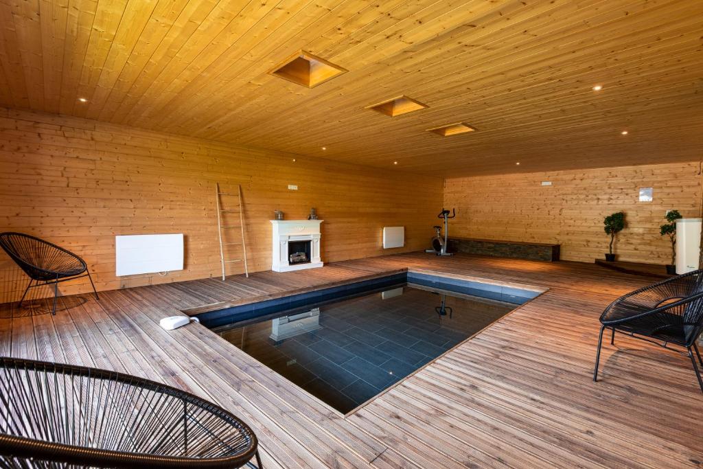 a swimming pool in a room with a wooden ceiling at Chalet Le Paradis Perdu in Fontpédrouse
