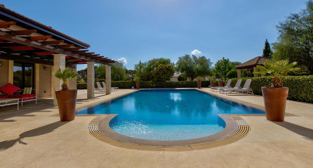 basen z krzesłami i altaną w obiekcie Villa Delphin 375 Fantastic villa with amazing outside space, Aphrodite Hills w mieście Kuklia