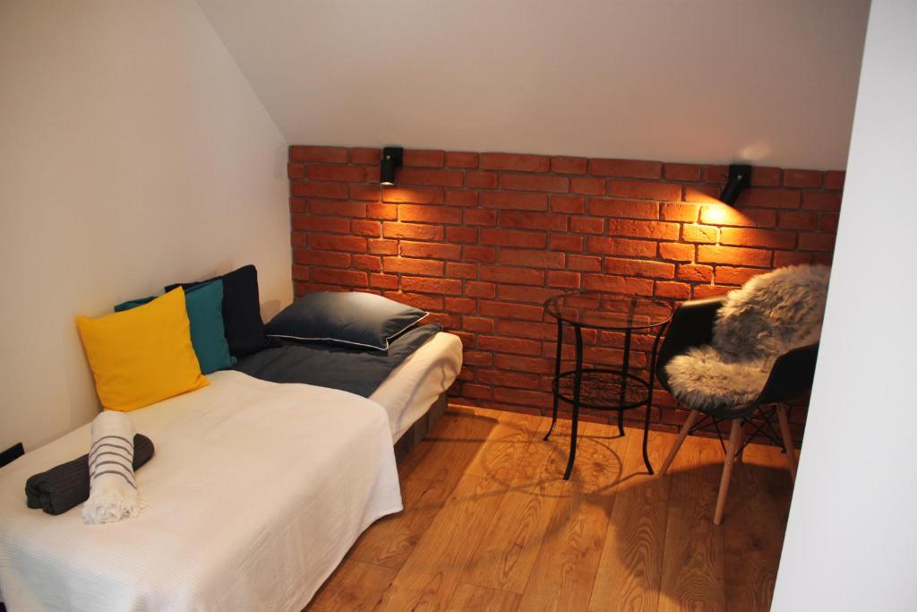 um quarto com duas camas e uma parede de tijolos em Leśny Zaułek em Muszyna