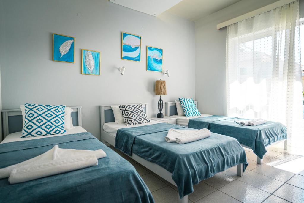 1 dormitorio con 2 camas y sofá en RODI BLUE appartments, en Amoudara Herakliou
