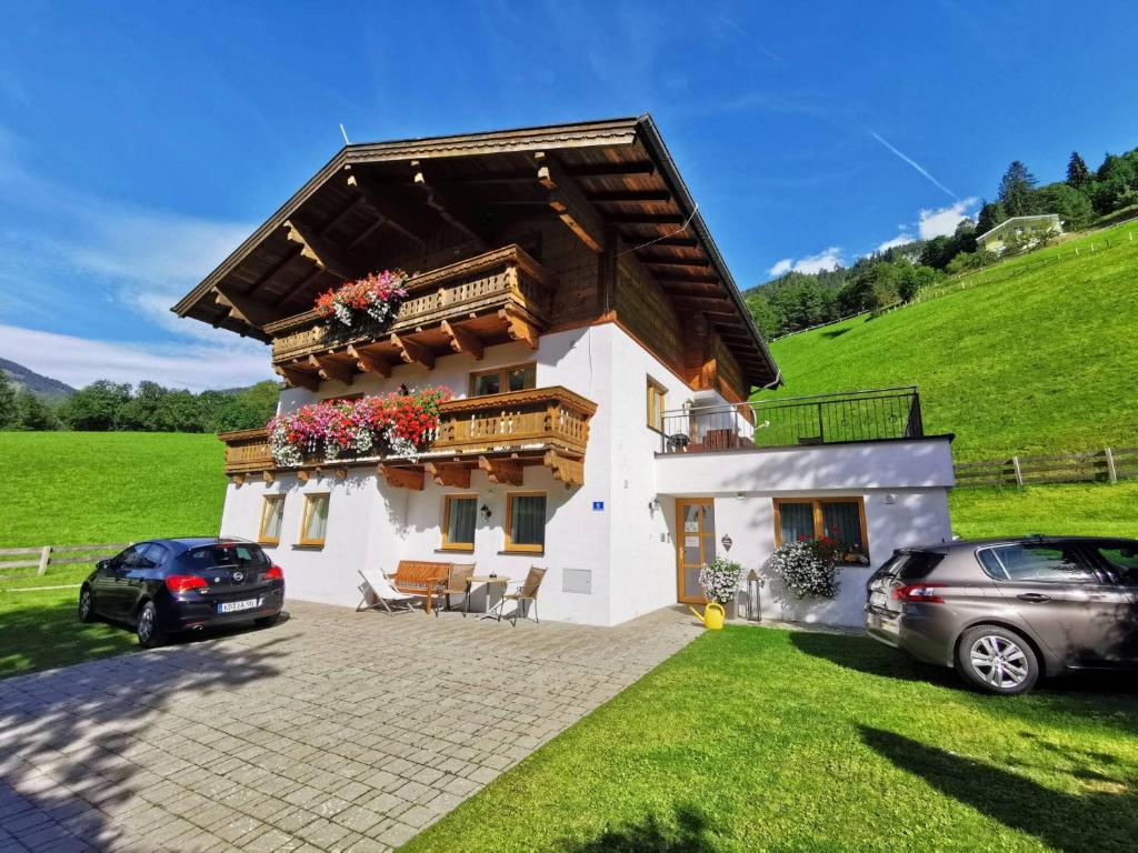 a house with two cars parked in front of it at Chalet Rehlein in Grossarl