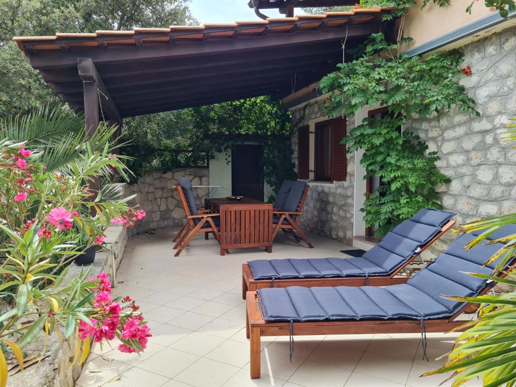 a patio with chairs and a table and a building at Studio apartment Ivan in Cunski