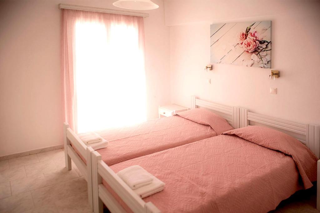 a bedroom with a bed with a window at Ios Penelope in Ios Chora