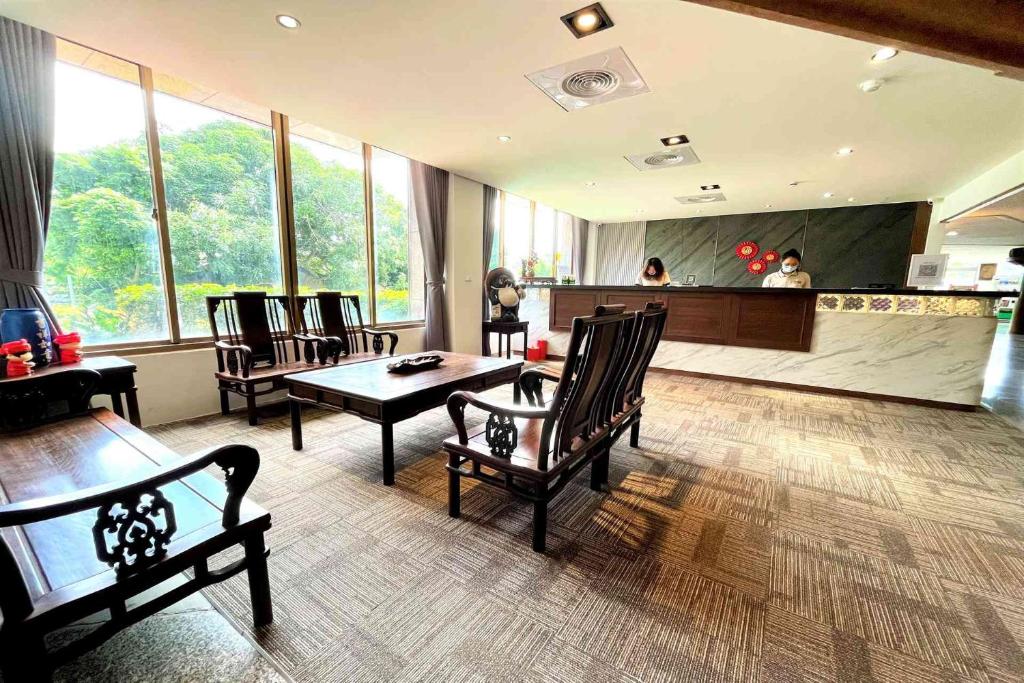 a living room with chairs and tables and a kitchen at Yawan Hotel in Wenquan