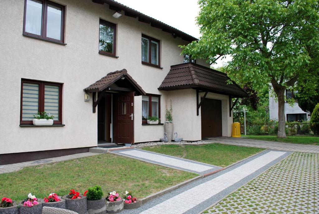 a house with a yard with flowers in front of it at Pokoje Gościnne Beata in Wisełka