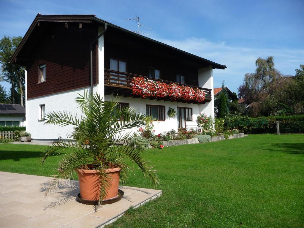 une maison avec une plante en pot devant elle dans l'établissement Ferienwohnung Wennesz 1, à Chieming